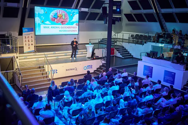 Christian Dietz bei seiner Neuromarketing-Keynote auf der Hauptbühne des OMT 2026, auf der Leinwand die drei größten Conversion-Killer