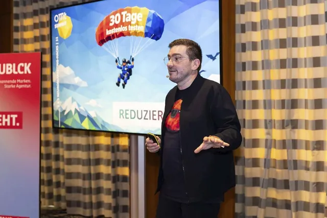 Christian Dietz auf der Bühne vor der Folie „30 Tage kostenlos testen“