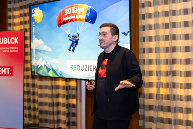 Christian Dietz auf der Bühne vor der Folie „30 Tage kostenlos testen“