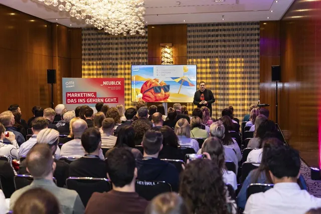 Neuromarketing-Vortrag auf dem OMT Summit: voller Saal, vorne Christian Dietz neben dem Banner „Marketing, das ins Gehirn geht“