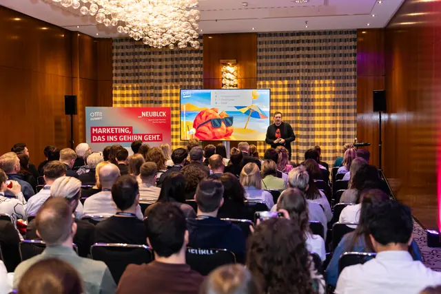 Neuromarketing-Vortrag auf dem OMT Summit: voller Saal, vorne Christian Dietz neben dem Banner „Marketing, das ins Gehirn geht“